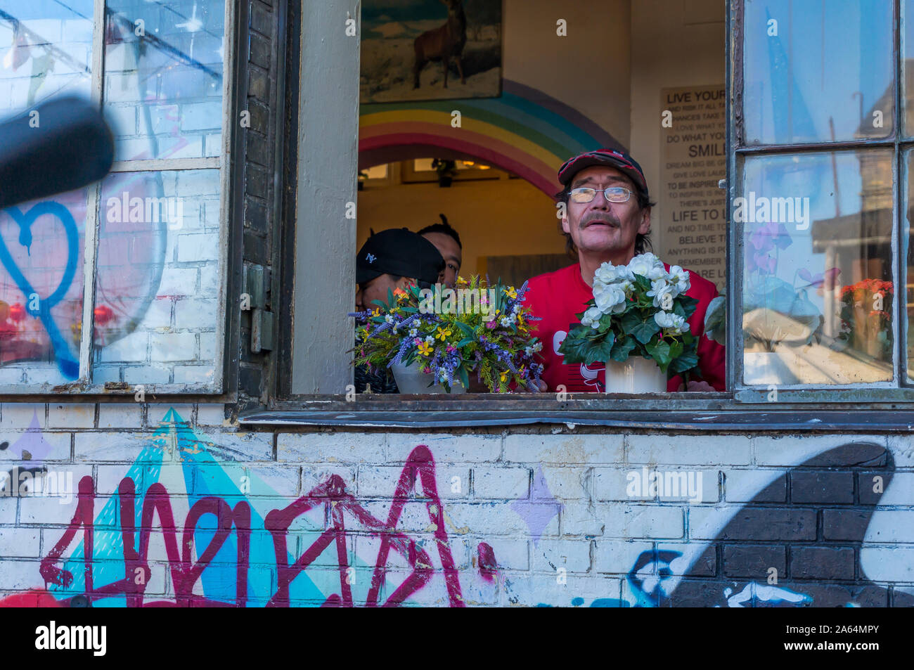 Authentic old men hippie in Freetown Christiania, the autonomous anarchist district in Denmark's capital. Copenhagen's colorful hippie haven. Happy hi Stock Photo