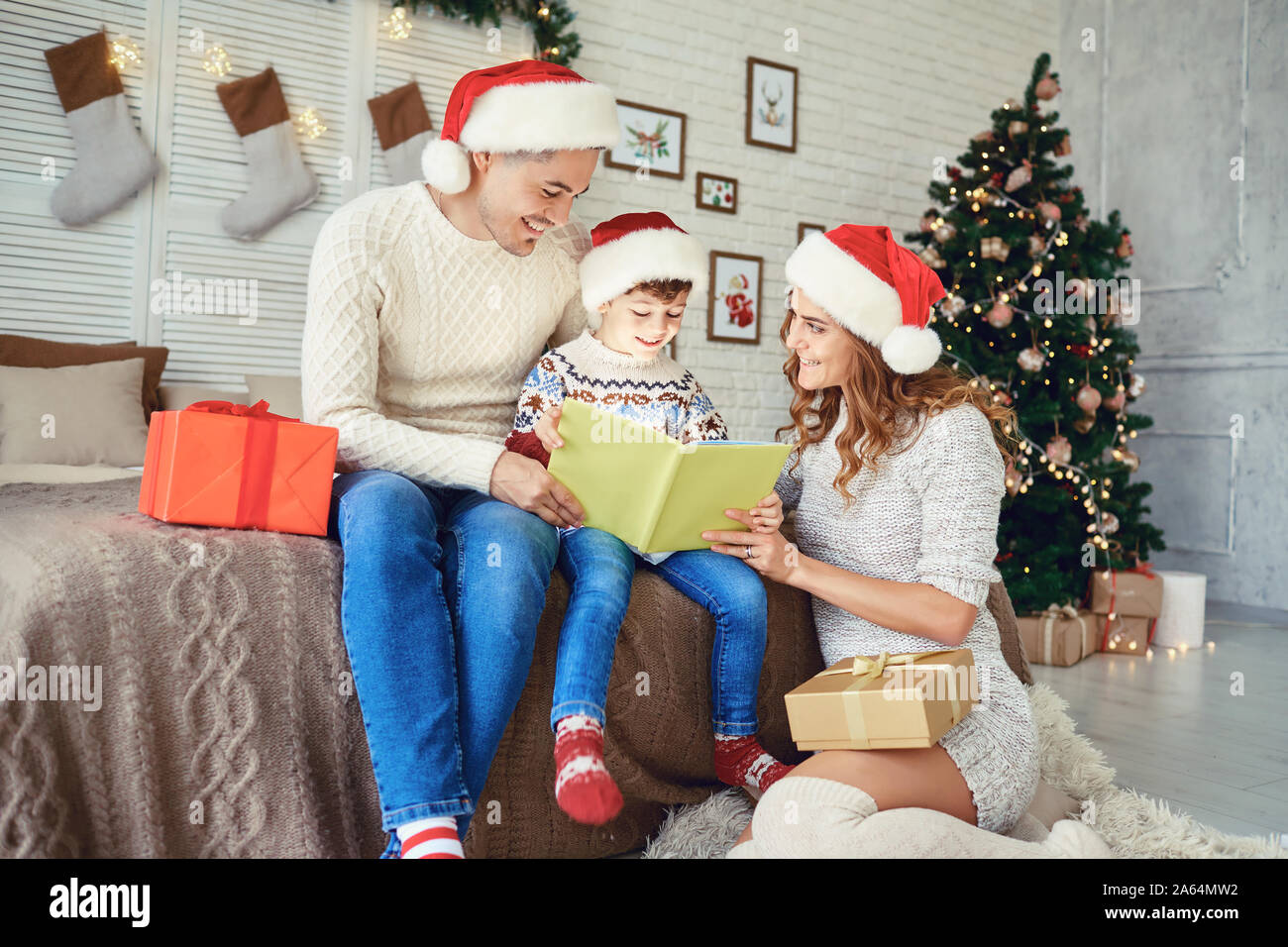 Family reading a bookin a house with a Christmas tree. Stock Photo