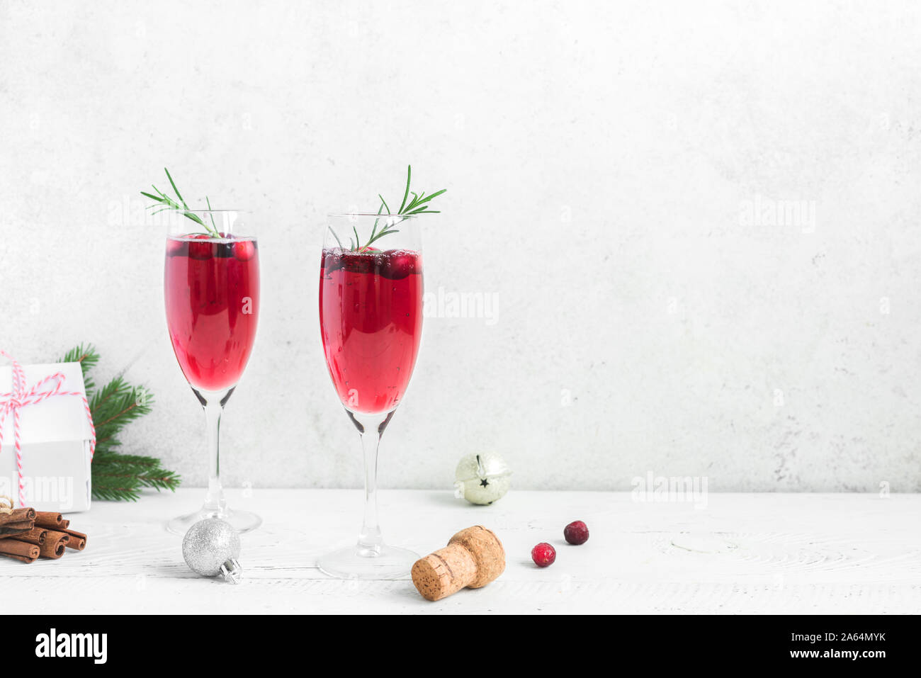 Christmas red cranberry mimosa with rosemary on white background, copy space. Cocktail with champagne for Christmas morning. Stock Photo