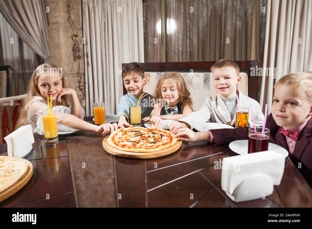 children eat pizza in a restaurant Stock Photo