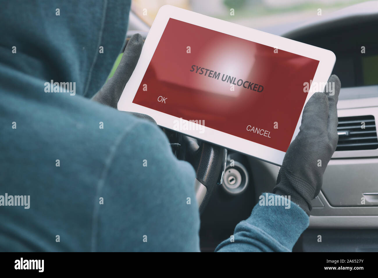 Hooded thief tries to break the car's security systems with tablet