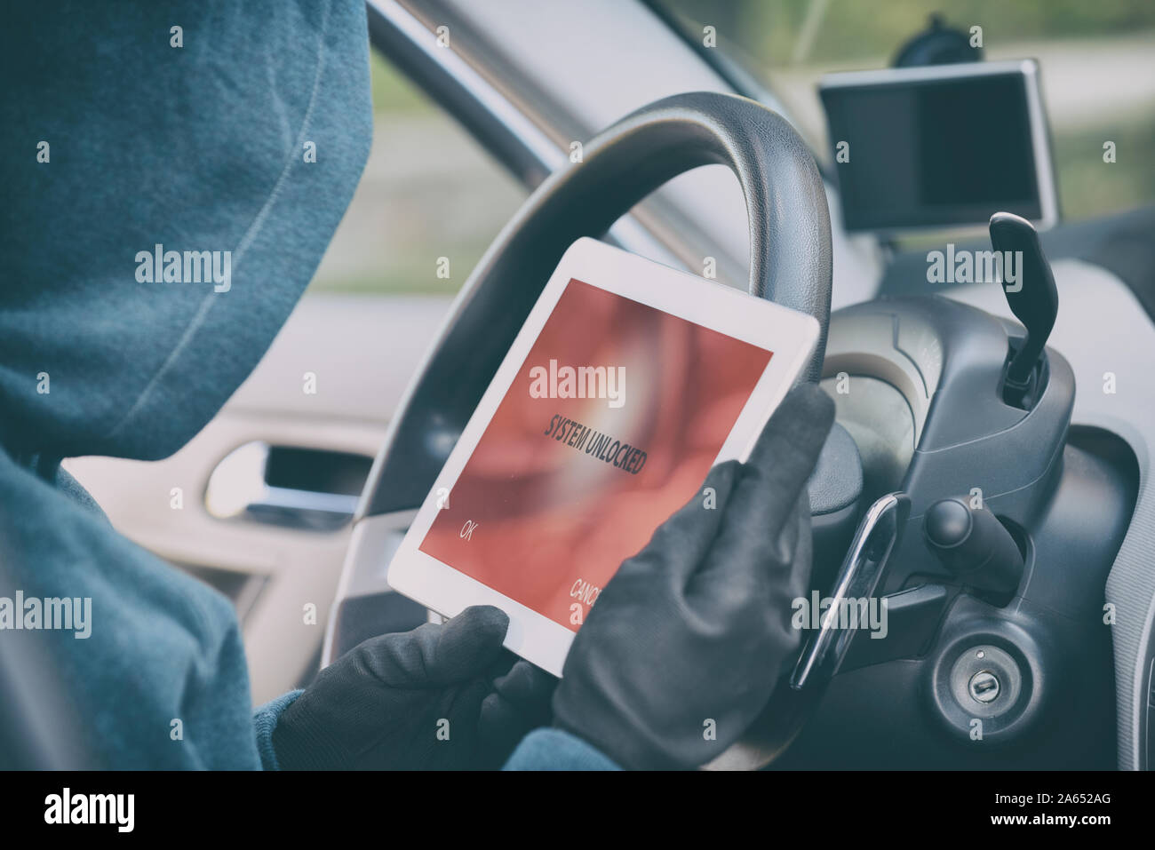 Hooded thief tries to break the car's security systems with tablet