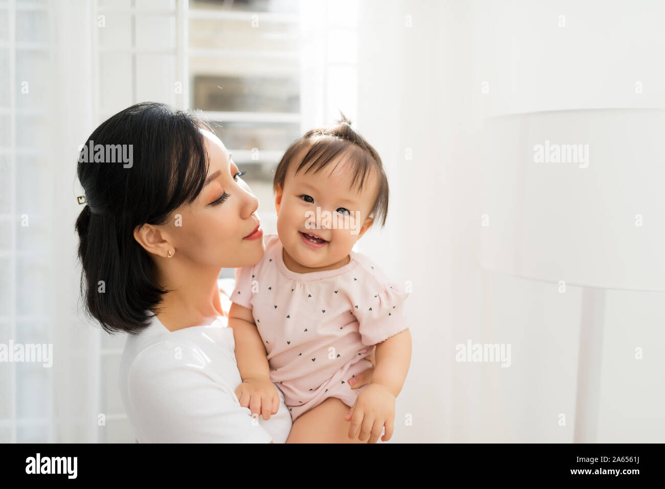 Portrait of happy vietnamese mother hugging with her cute little ...