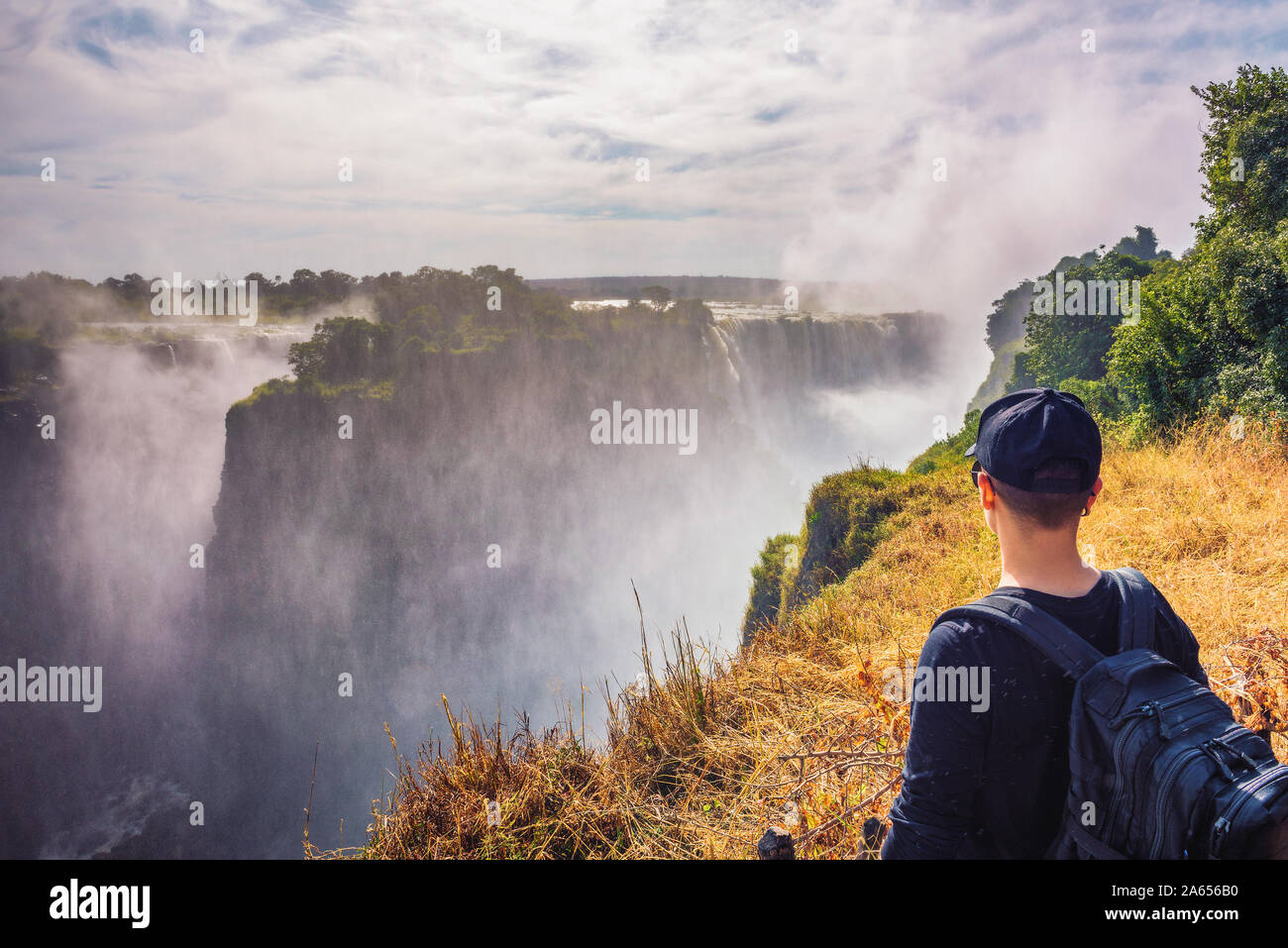 Tourist looks at the Victoria Falls on Zambezi River in Zimbabwe Stock Photo