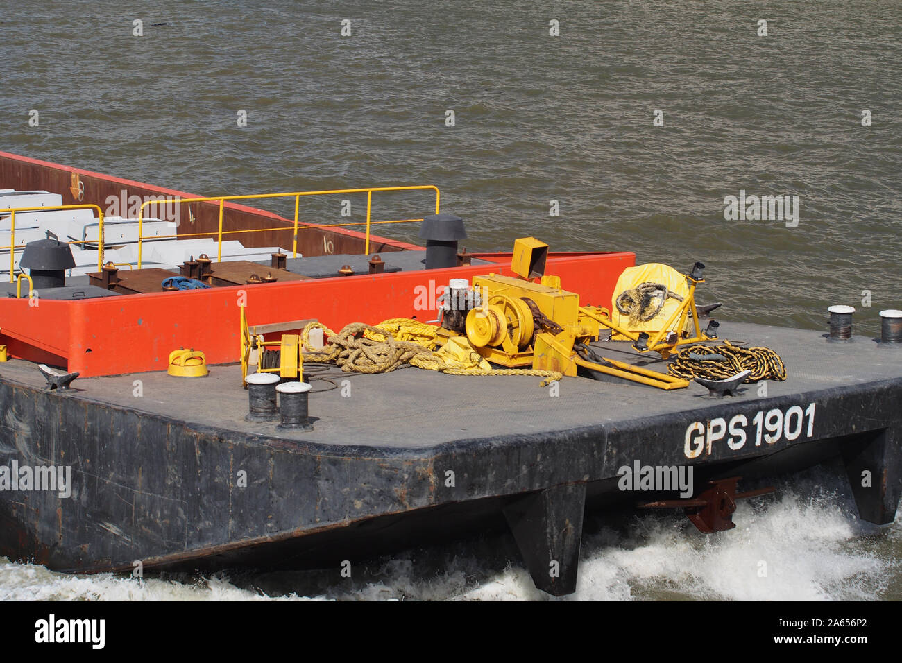 A close up view of the front of a working, moving barge on the River Thames at Westminster with ropes, pulleys and general gear on board Stock Photo