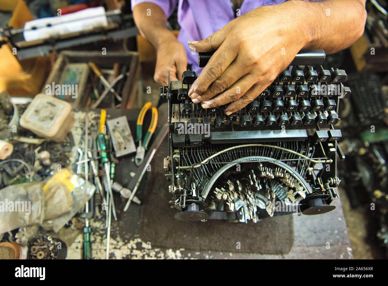 Technician repairing old manual typewriter, Bombay, Mumbai, Maharashtra, India, Asia Stock Photo