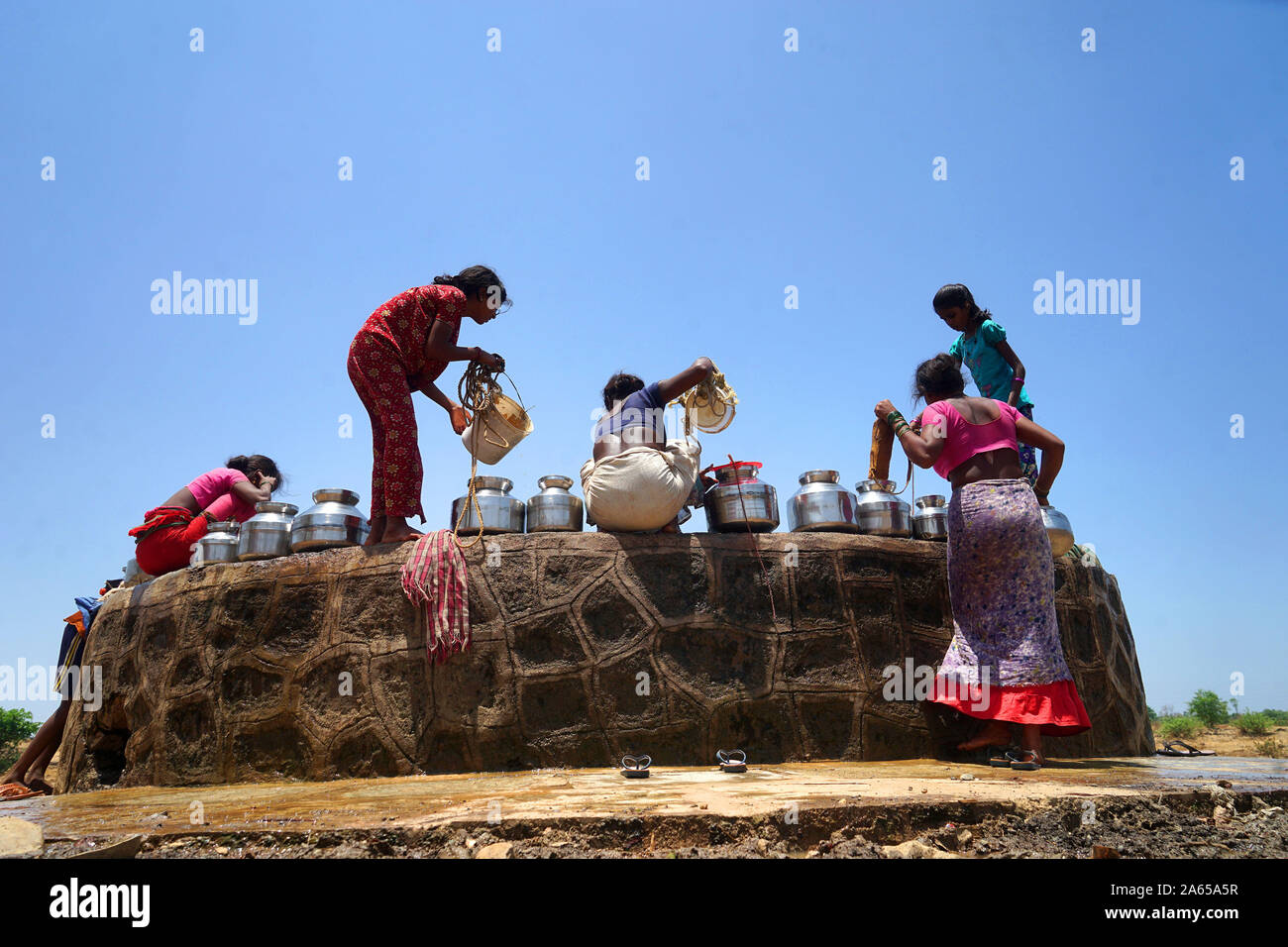 Women collecting water from well at Dhakne village, Shahapur Thane Maharashtra, India, Asia Stock Photo