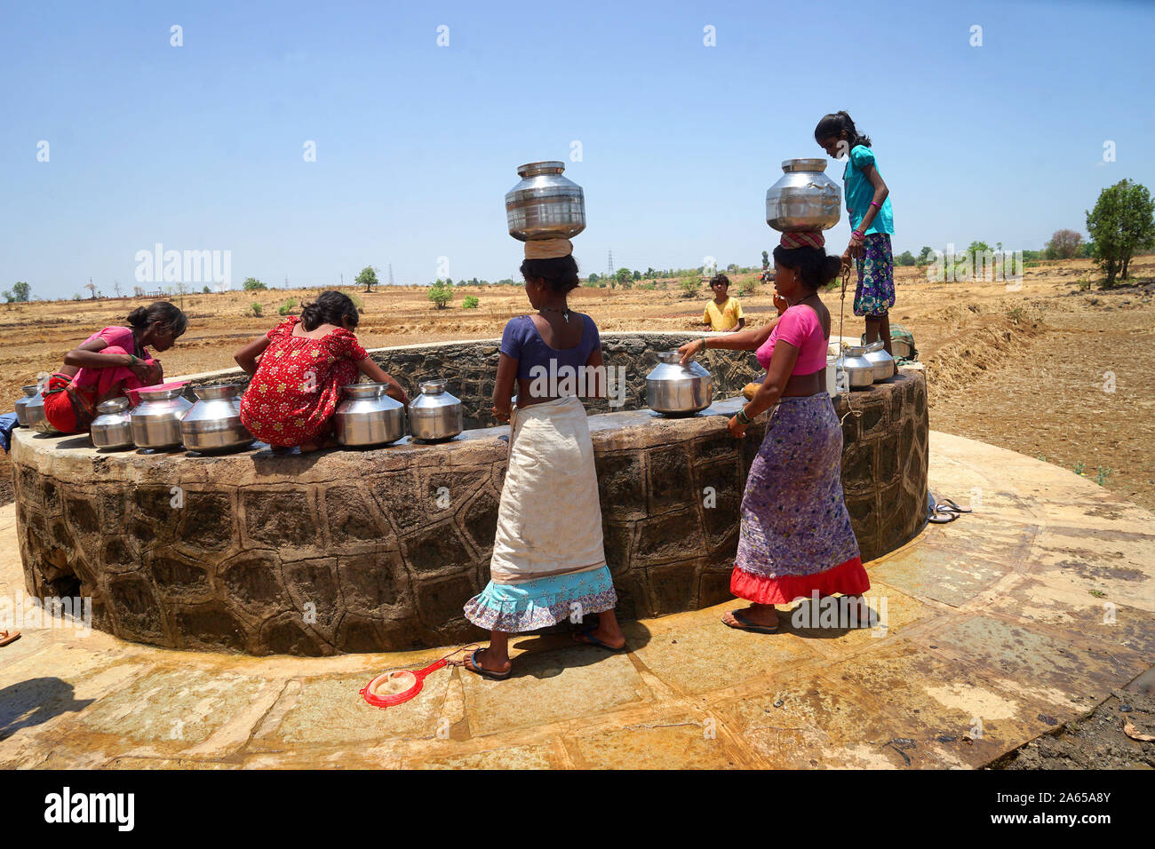 rural women collecting water from village well at Dhakne village, Shahapur Thane Maharashtra, India, Asia Indian village Stock Photo
