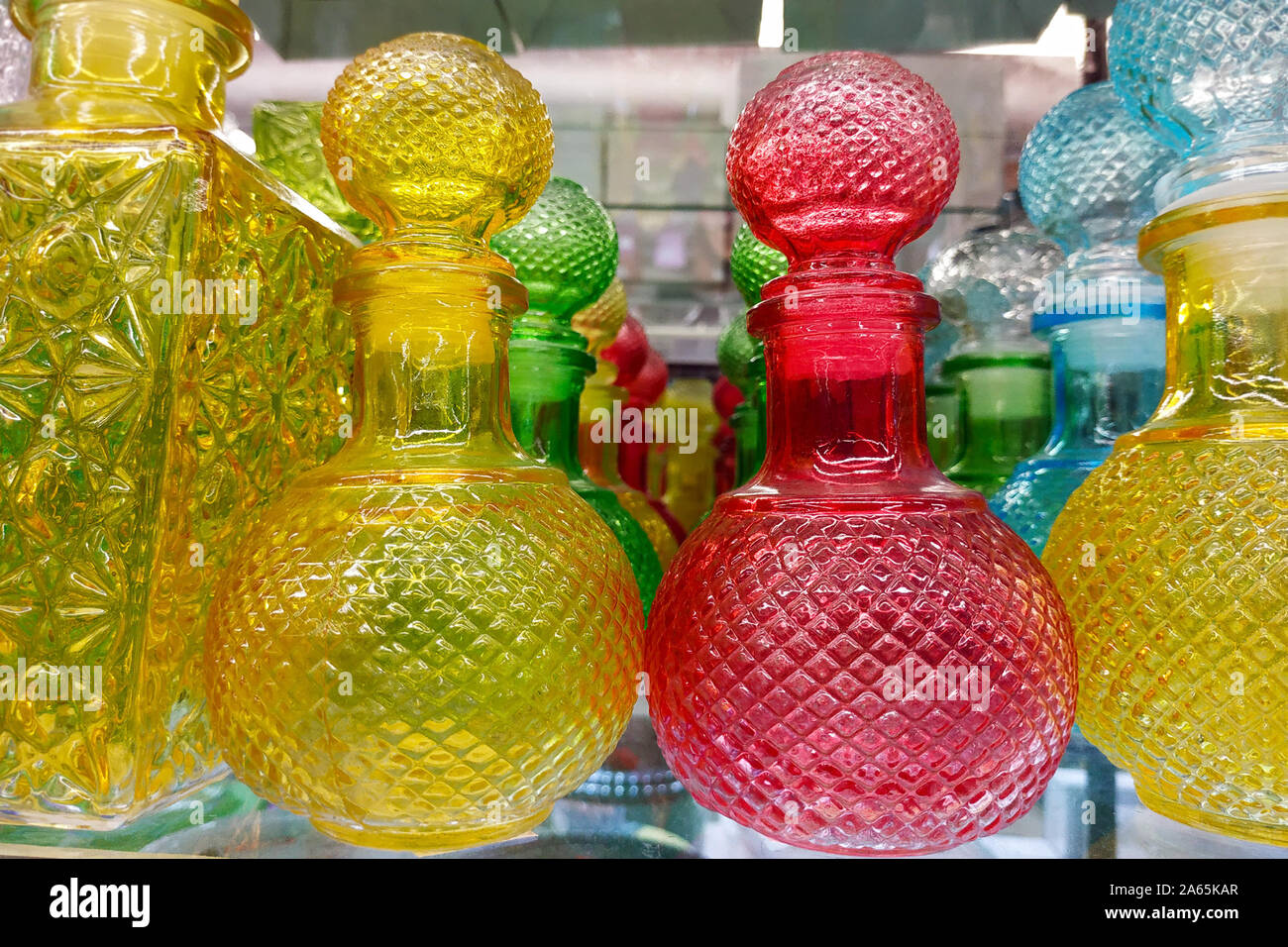 Yellow, red and blue decanters closeup. Faceted decanters of different