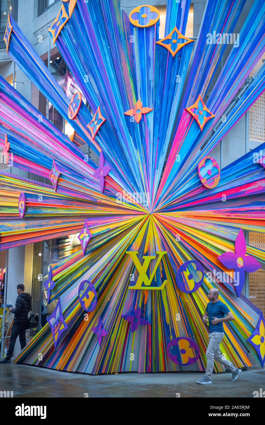New Bond Street, London, UK. 24th Oct 2019. The refurbished Louis Vuitton  store re opens with a huge and colourful explosion of stars installation on  its corner outside wall. Credit: Guy Bell/Alamy