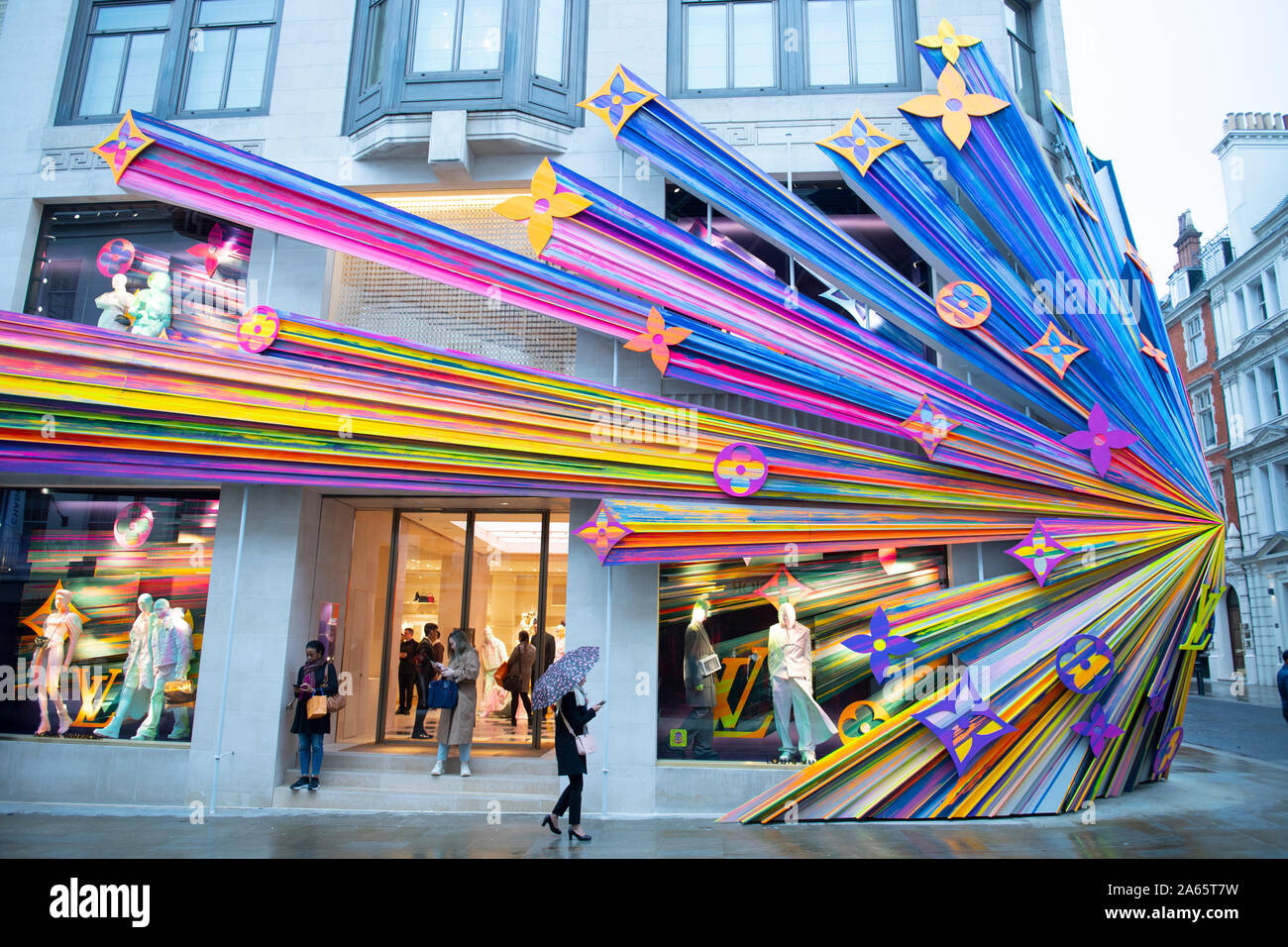New Bond Street, London, UK. 24th October 2019. The new Louis Vuitton store opening day in New Bond Street with a big splash of colour spectrum on a grey and wet London morning. Credit: Malcolm Park/Alamy Live News. Stock Photo