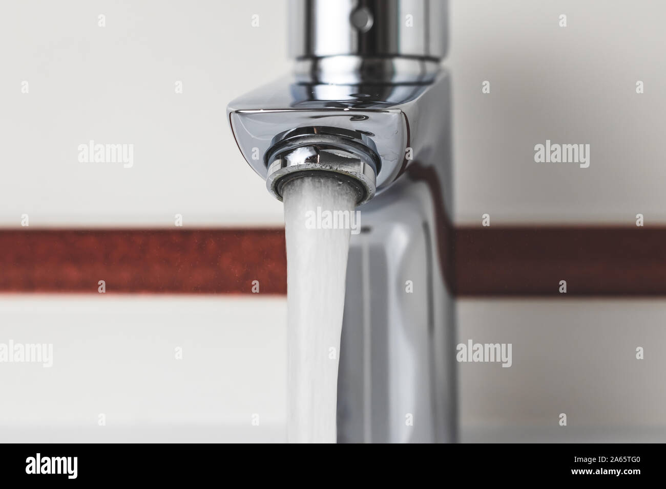 Water tap close-up. Water flow, stream. Water is pouring from the tap. Stock Photo