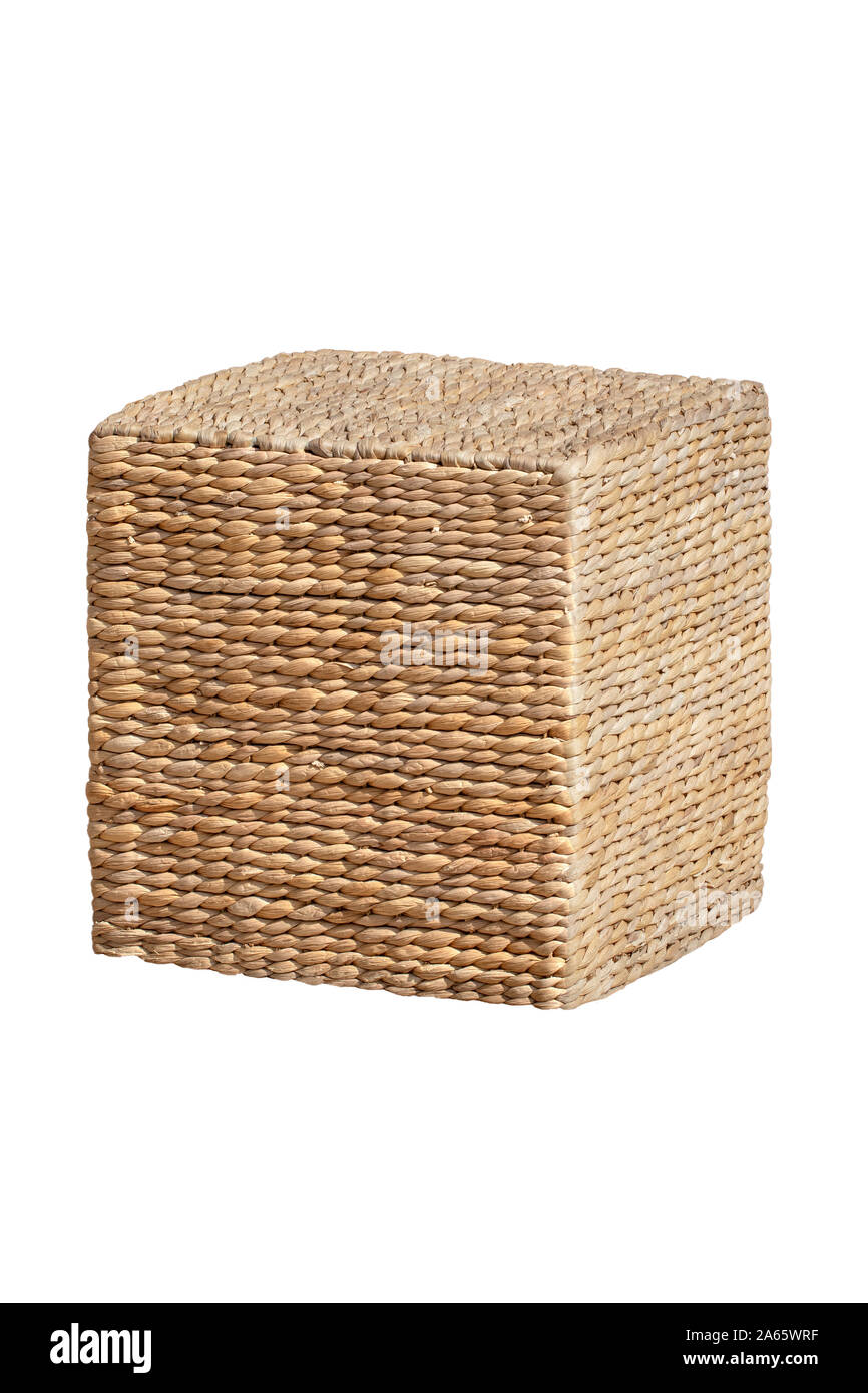 Wicker furniture. Close-up of wicker stool in the form of a cube is also used as a storage next to couches at the hotel swimming pool. Pool accessorie Stock Photo