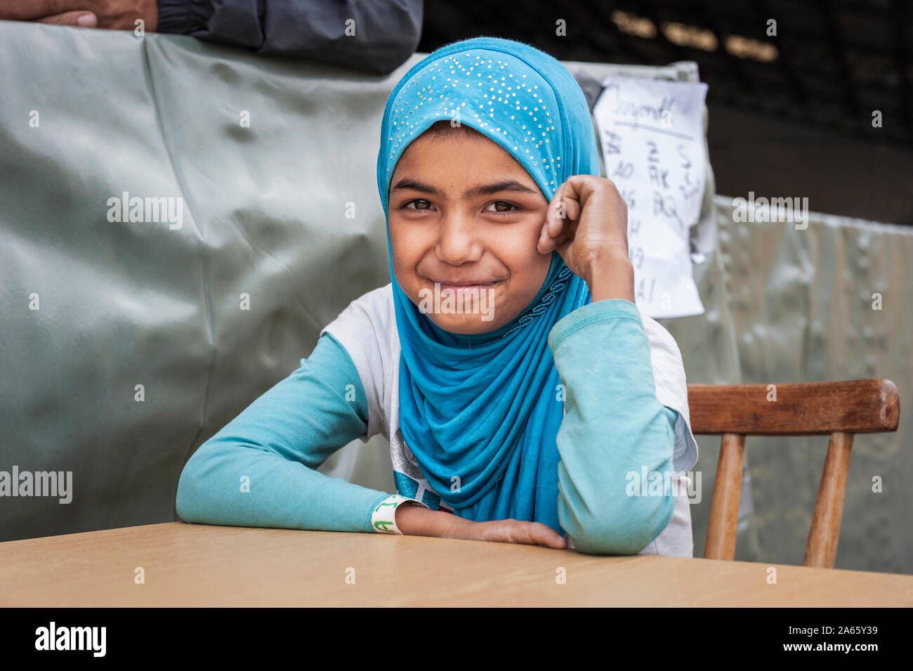 Passau, Germany - August 1st, 2015: Syrian refugee girl at a camp in Passau, Germany. The police and several organisations try to push them through re Stock Photo