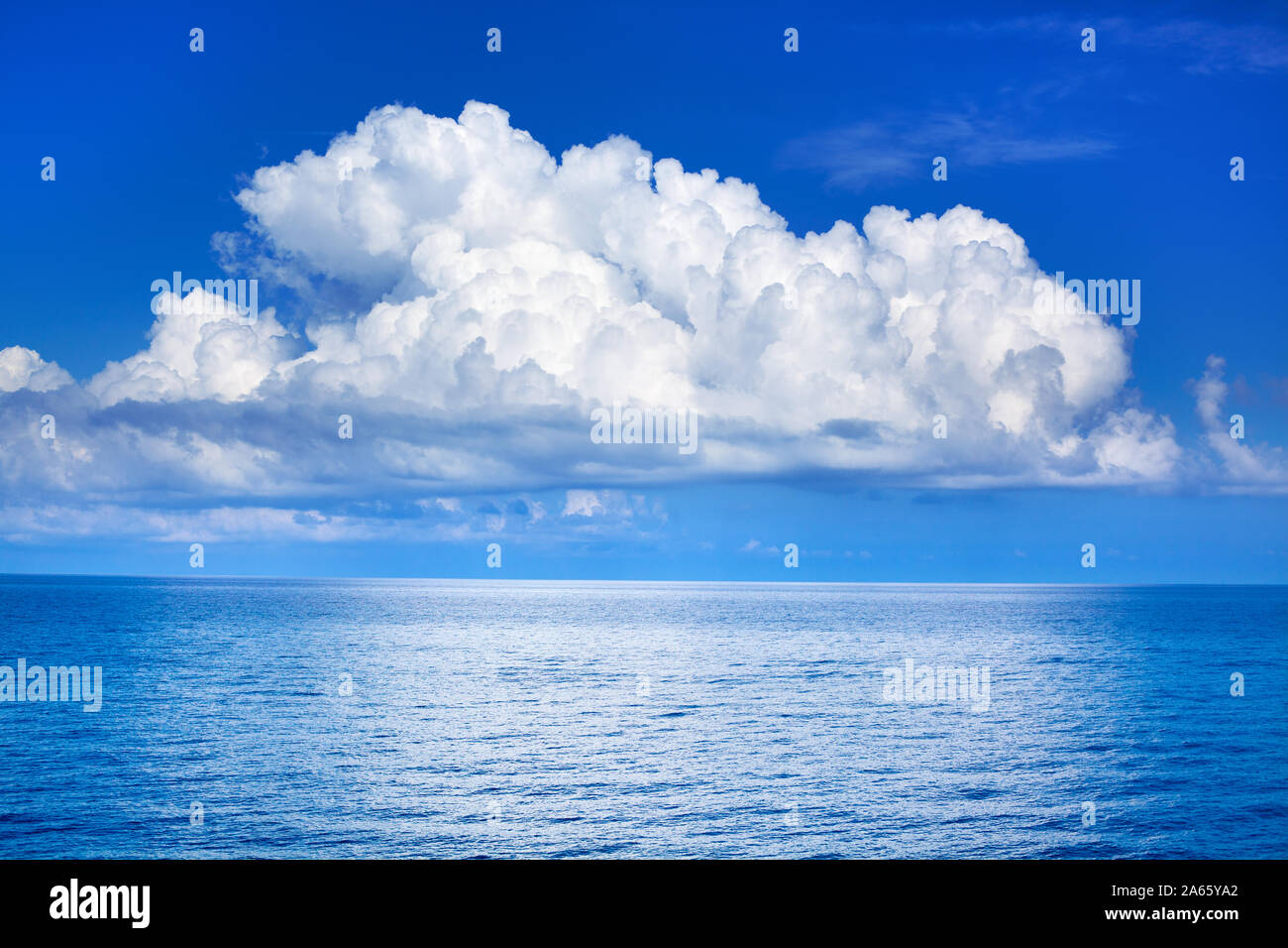 White cumulus clouds in blue sky over sea landscape, big cloud above ...