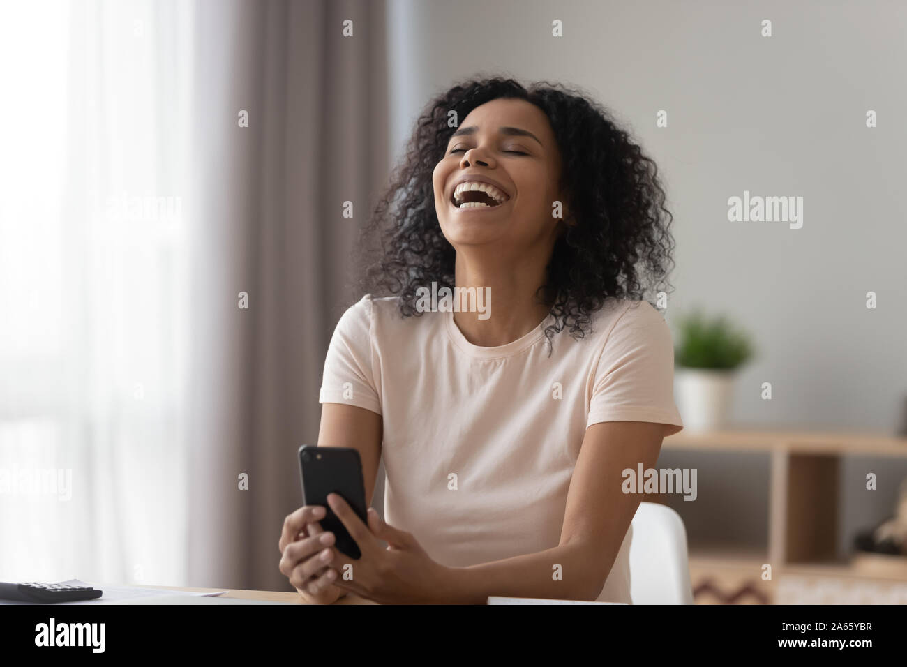 African woman laughing text message hi-res stock photography and images ...