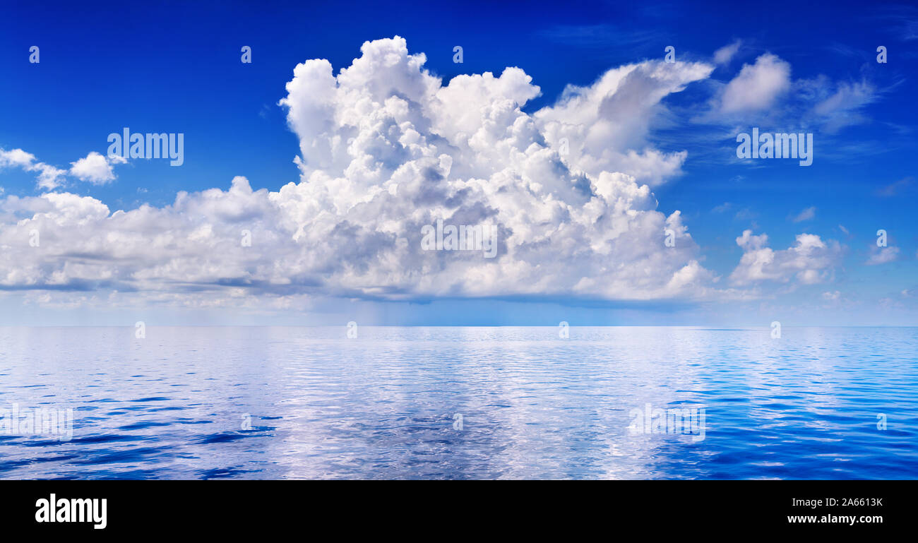 White cumulus clouds in blue sky over sea landscape, big cloud above ...