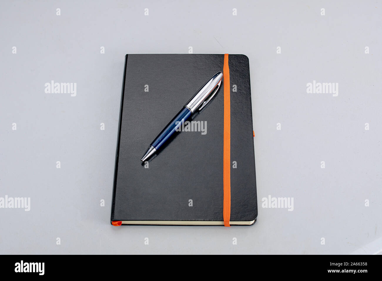 Bound notepad with black hardcover and modern blue and silver pen Stock Photo