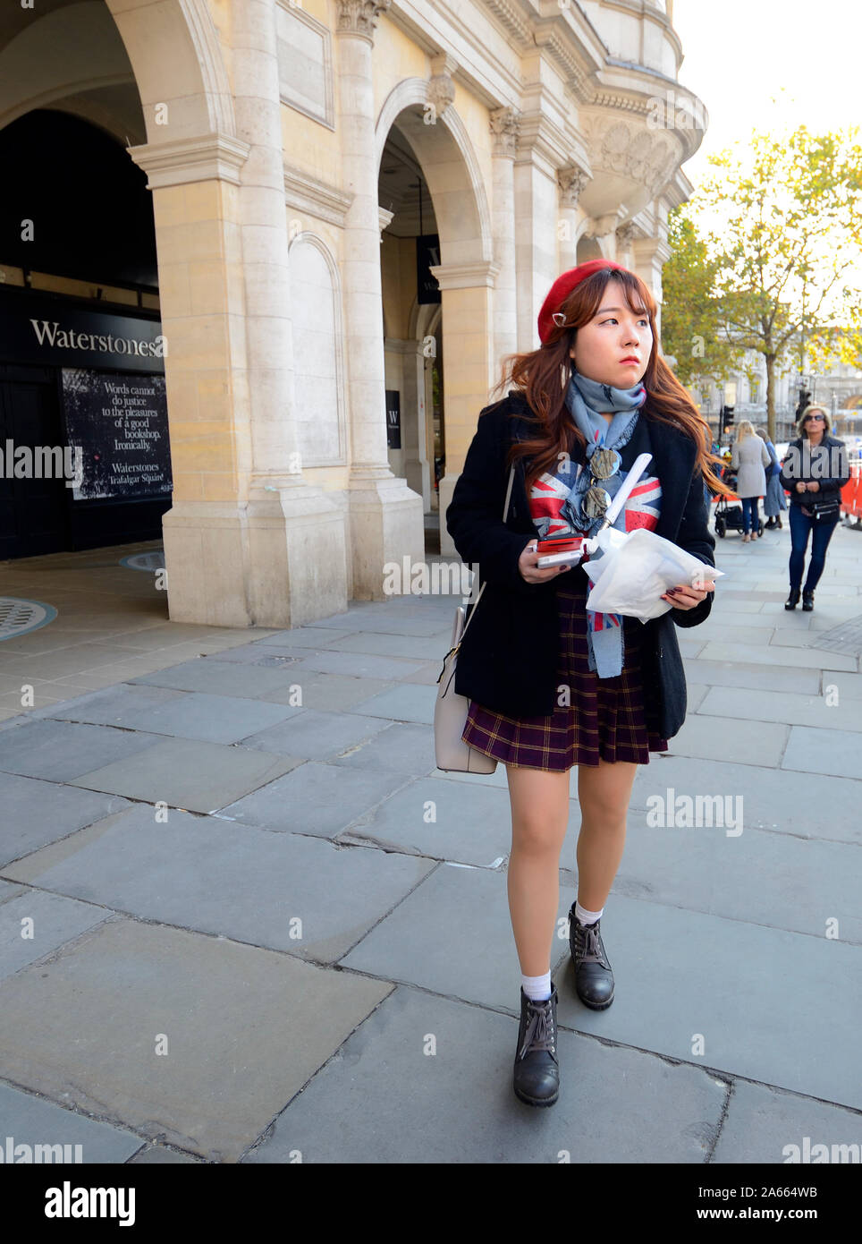 London, England, UK. Young female Japanese tourist in Trafalgar Square Stock Photo