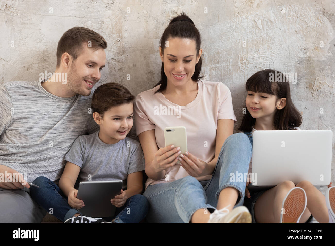Happy addicted to technology family using different gadgets Stock Photo ...