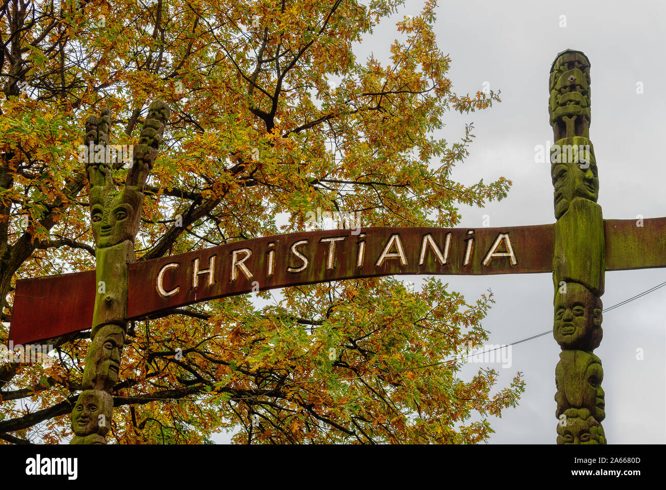 A sign between two totem poles over the gate to the freetown Christiania in Copenhagen, October 22, 2019 Stock Photo