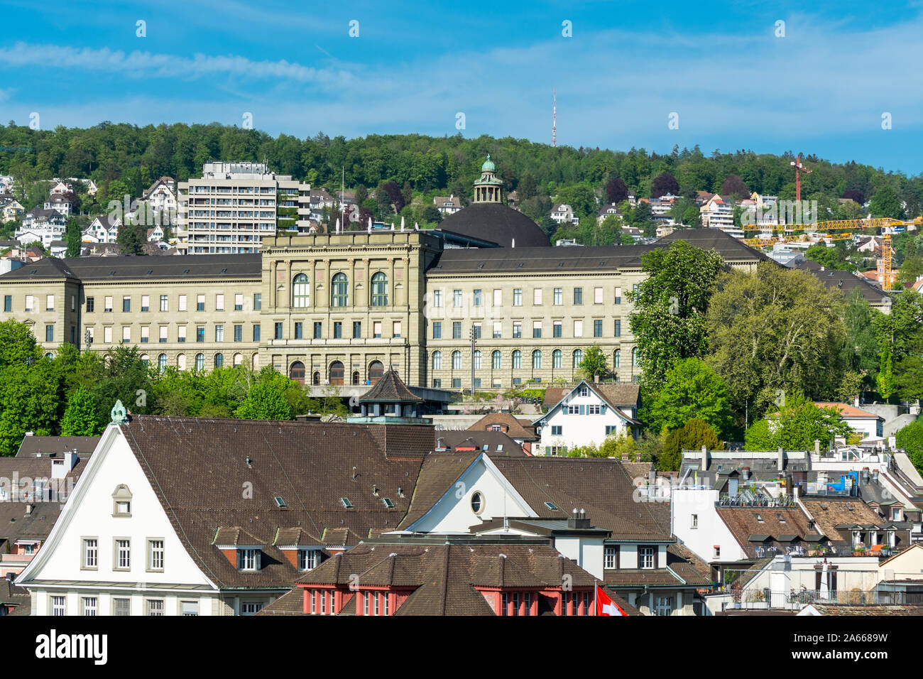 View of the historic center of Zurich at the bank of Limmat River, with beautiful house rooftops and main building of ETH , view form Lindenhof hill. Stock Photo