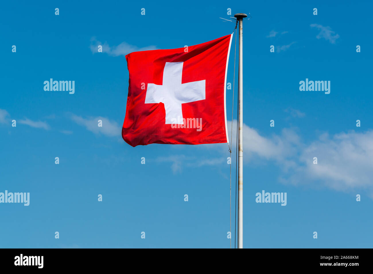 National flag of Switzerland flying at the Zurich lake against blue sky