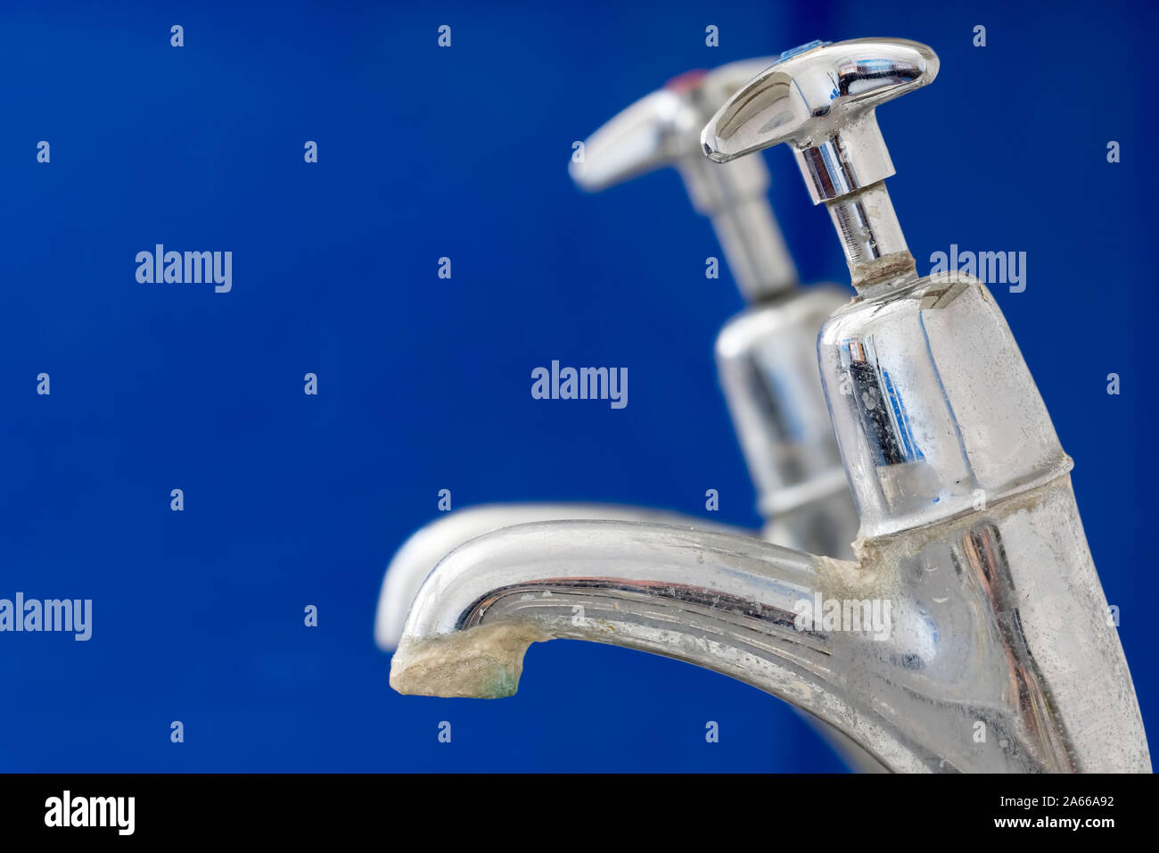 Limescale. Chrome faucet with hard water calcification deposit close-up. Tap needing decalcification and water softener. Scale build-up on old kitchen Stock Photo