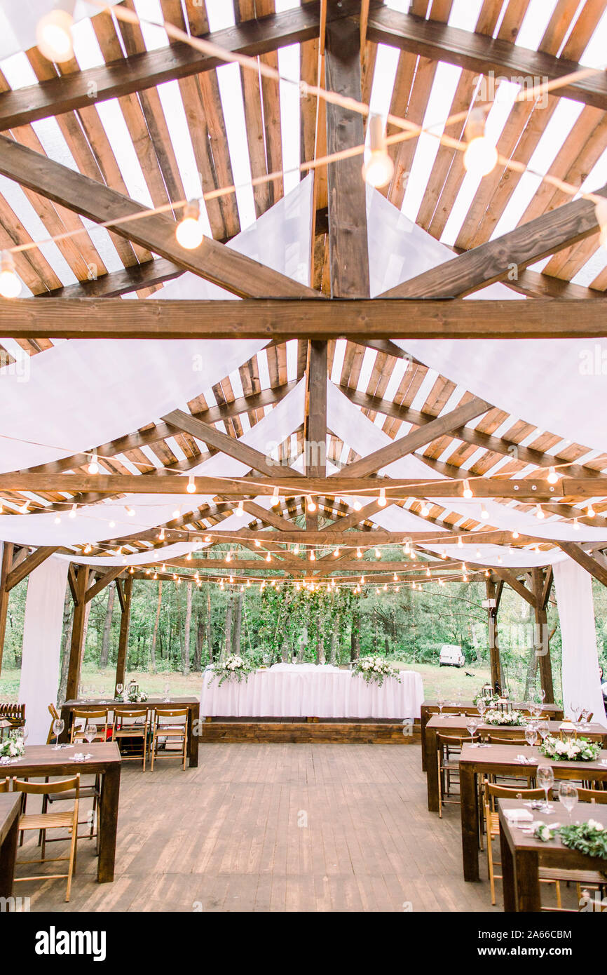 Interior of a wedding tables in rustic tent from wood, decorated with light  bulbs, ready for guests. Served banquet tables outdoor decorated with Stock  Photo - Alamy, image size:866x1390
