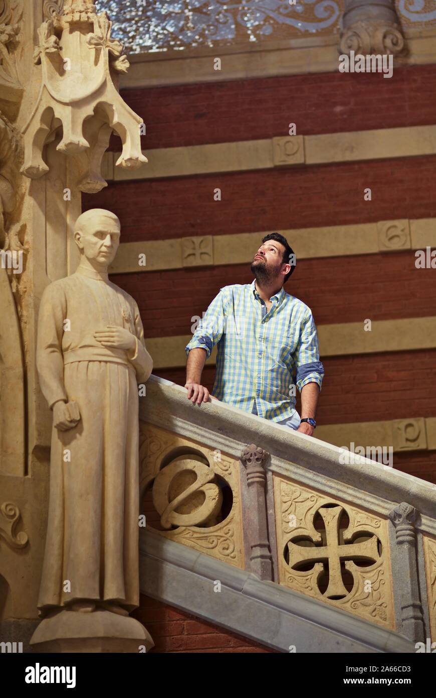 Man posing on stairs inside Recinte Modernista de Sant Pau, Barcelona Stock Photo