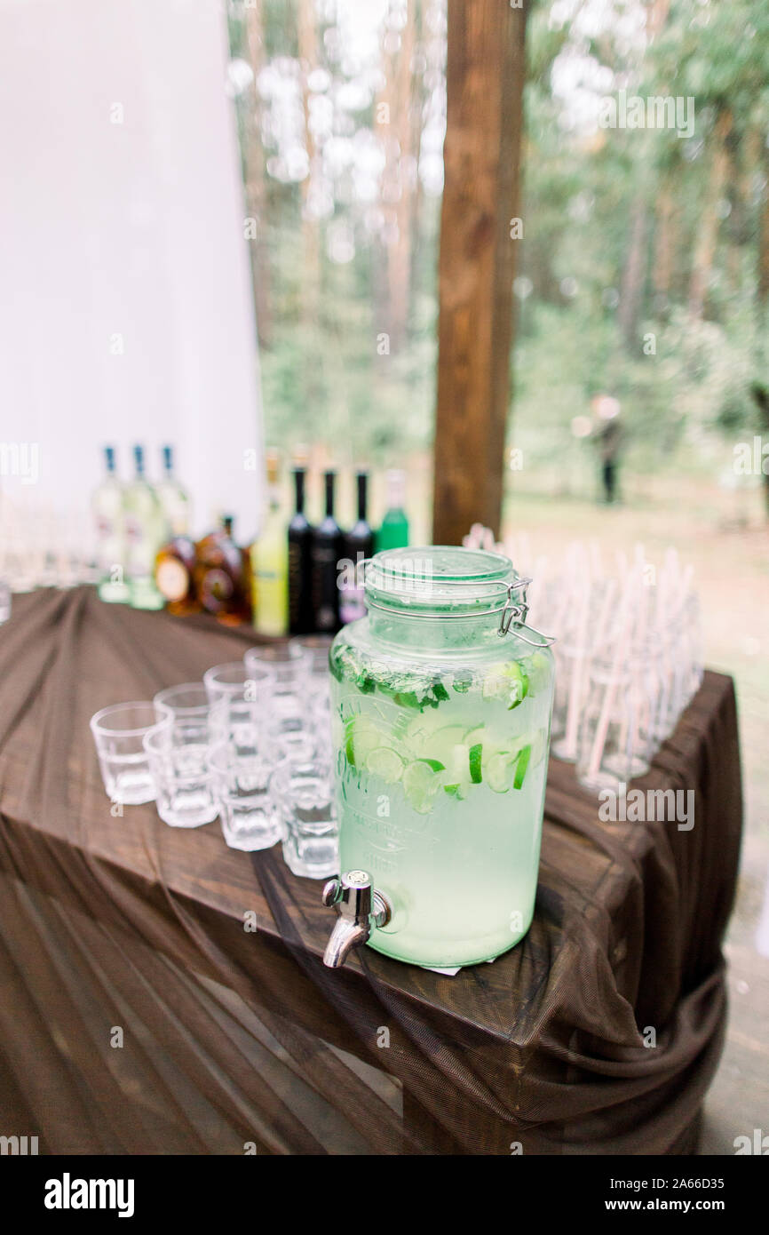 Lemonade Jar And Glasses For Alcohol Drinks On Wooden Table