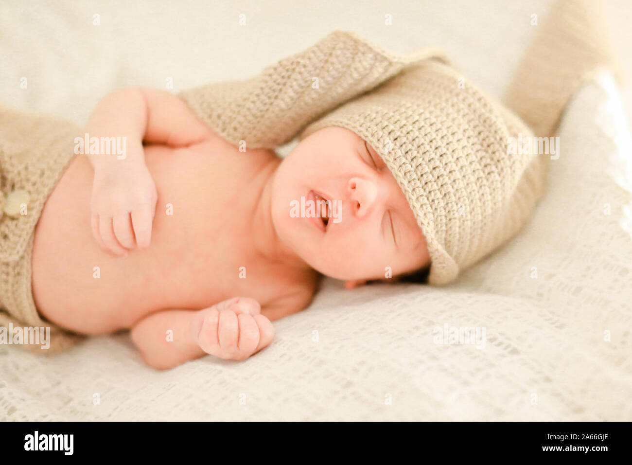 Nice newborn baby sleeping and wearing crocheted clothes Stock Photo