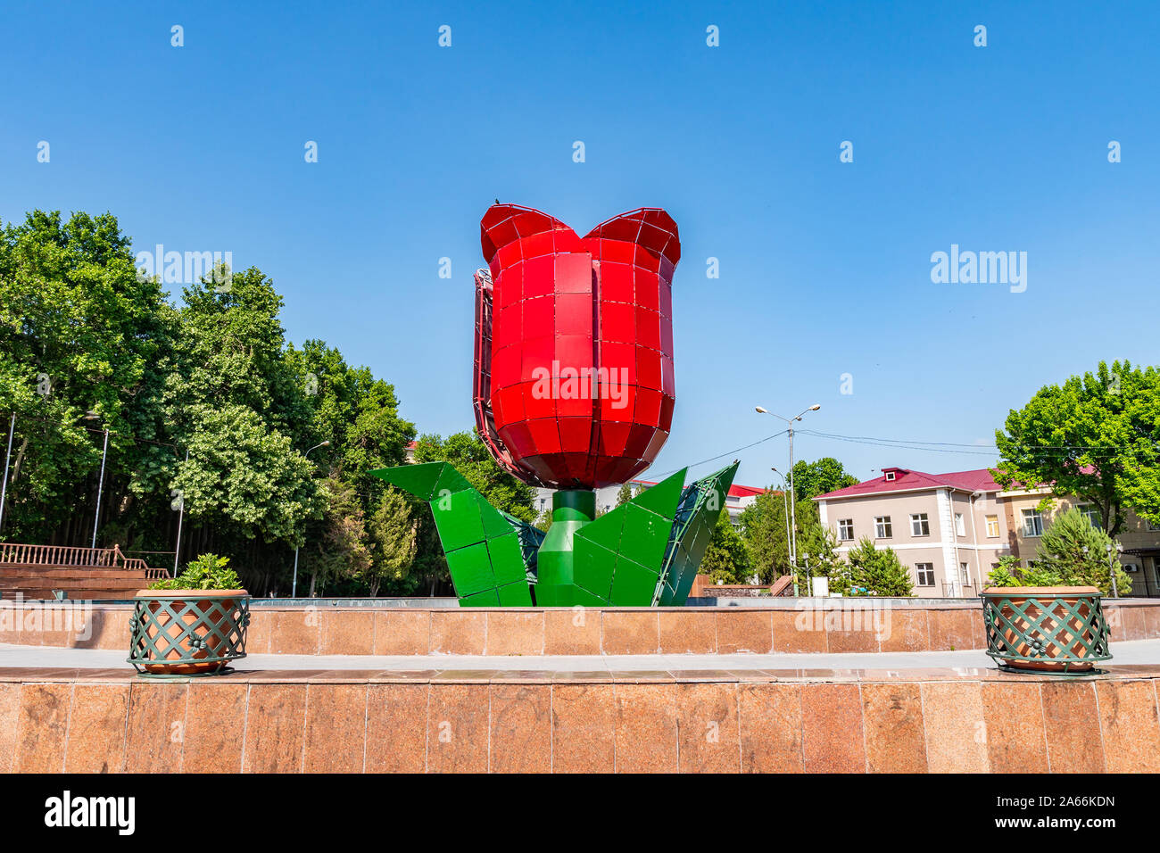 Shymkent South Kazakhstan State University Auezov with Red Tulip Flower Sculpture on a Sunny Blue Sky Day Stock Photo