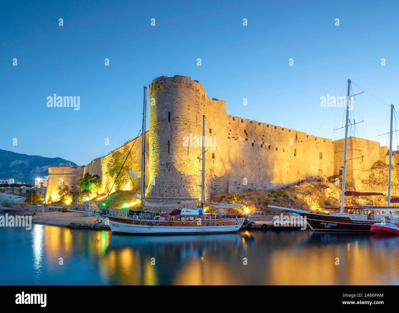 Boats in front of Kyrenia Castle (Girne Kalesi) at night, Kyrenia (Girne), Kyrenia (Girne) District, Cyprus (Northern Cyprus). Stock Photo