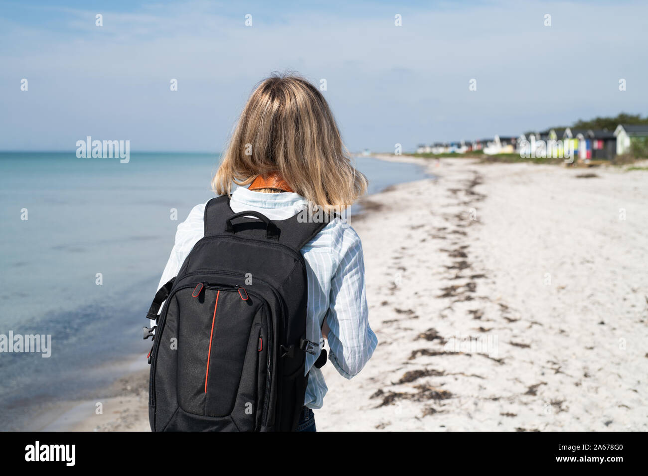 woman with backpack on beach Stock Photo