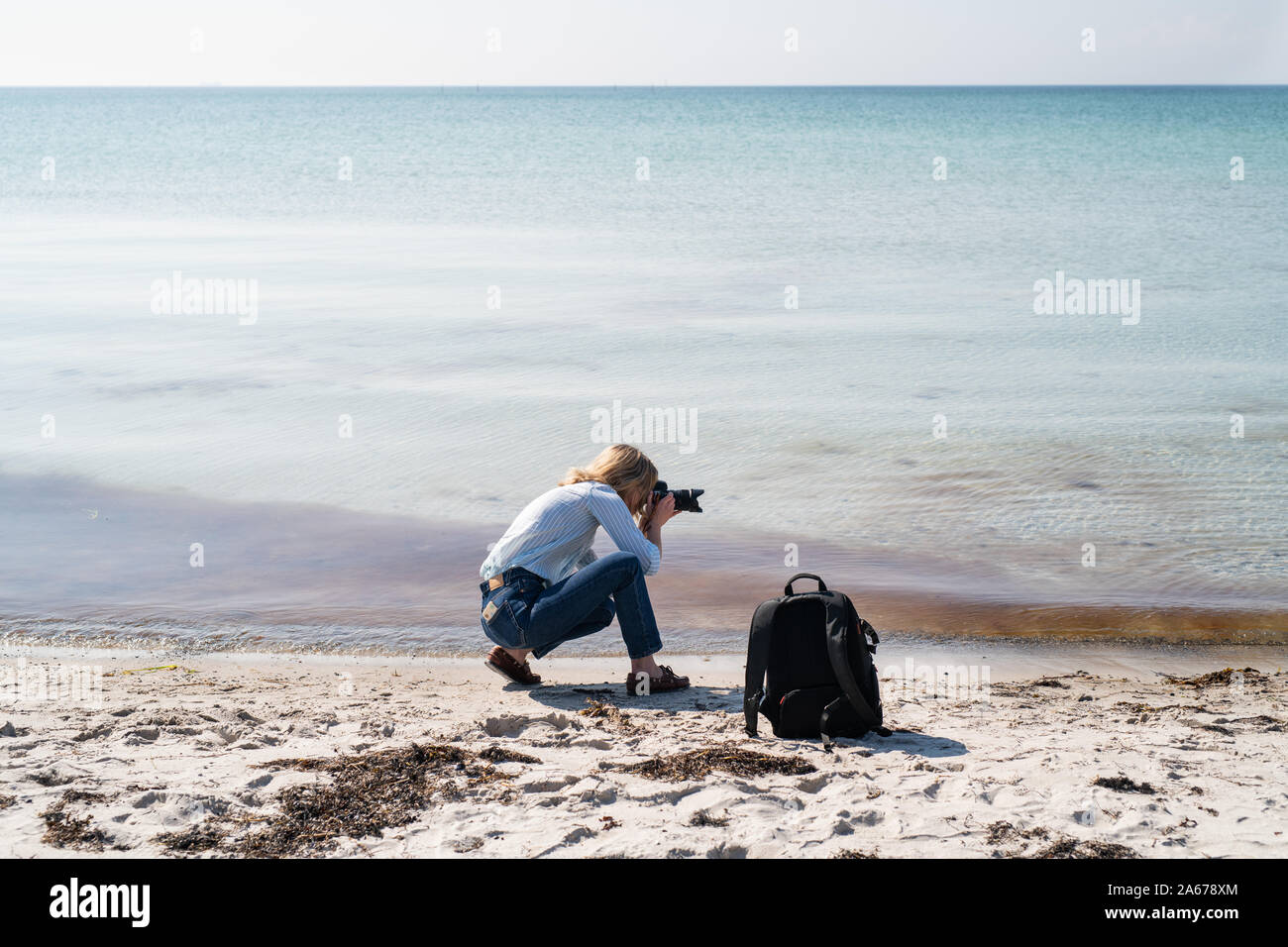 Woman photographing from a beach Stock Photo