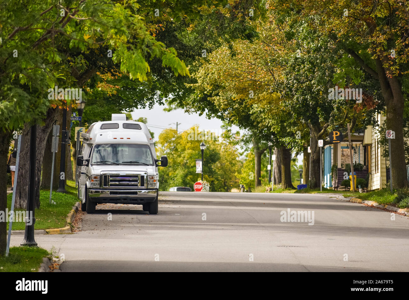 Van Lifestyle concept. Van parked in a street between trees in Autumn. Gananoque, Canada. Stock Photo