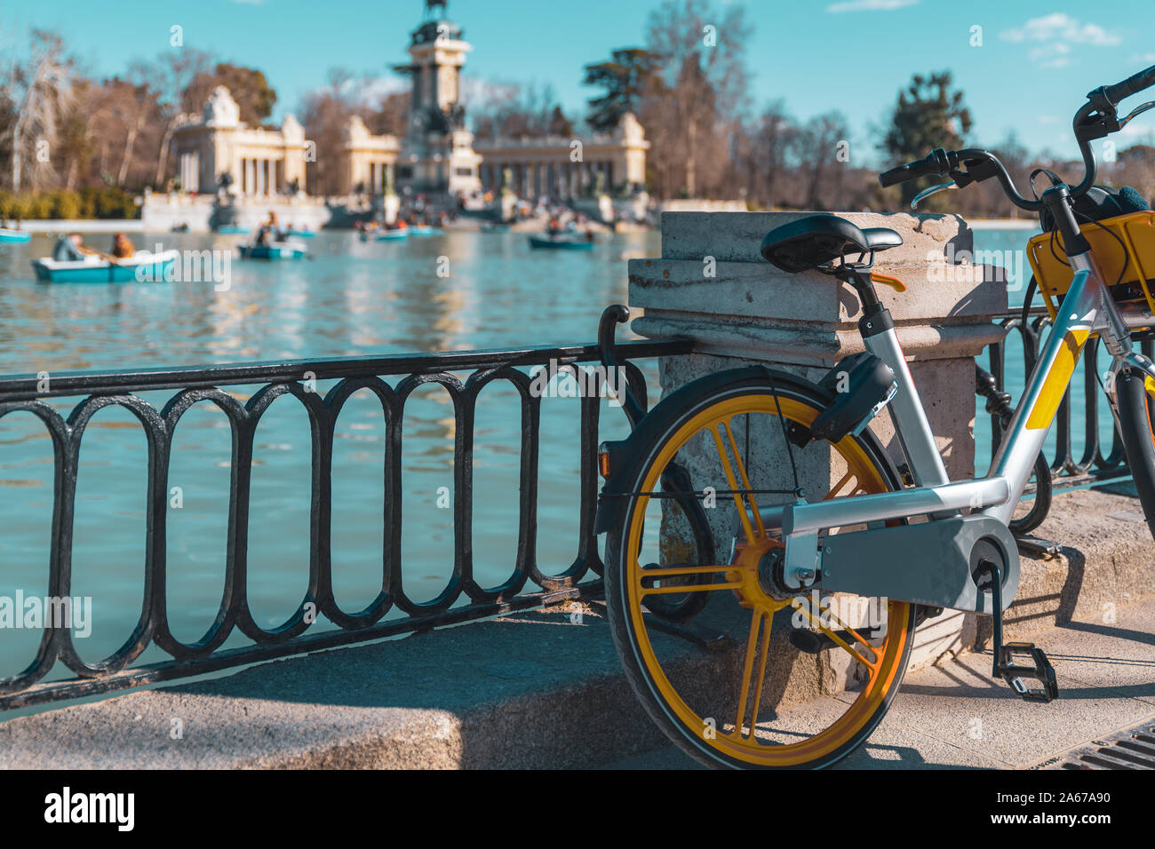 Electric bicycle rental in the foreground and the park of the Retiro in the background out of focus. Sustainable lifestyle Stock Photo