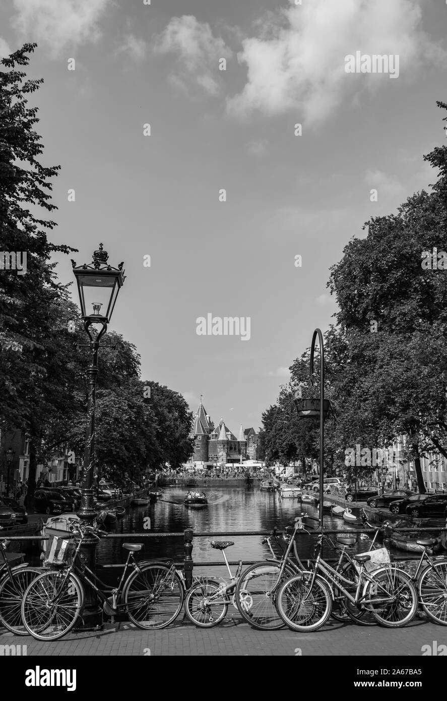 A black and white picture of a bridge full of bikes over a canal in