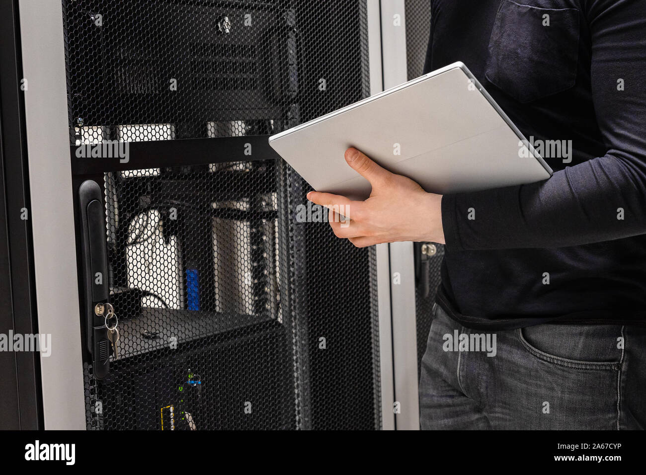 Midsection of IT Support Using Digital Tablet in Large Datacenter Stock Photo