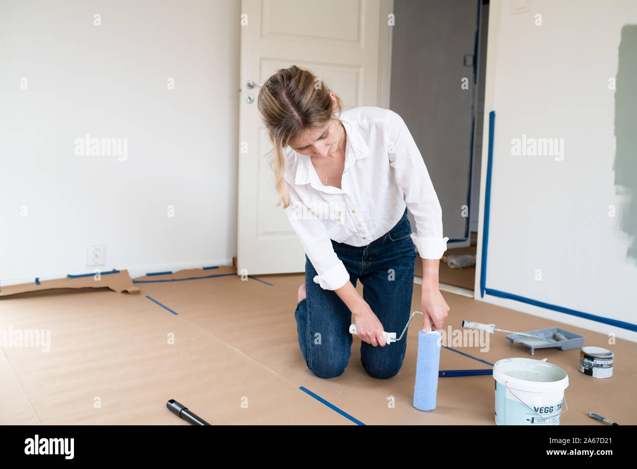 woman attaching a roller before painting Stock Photo Alamy