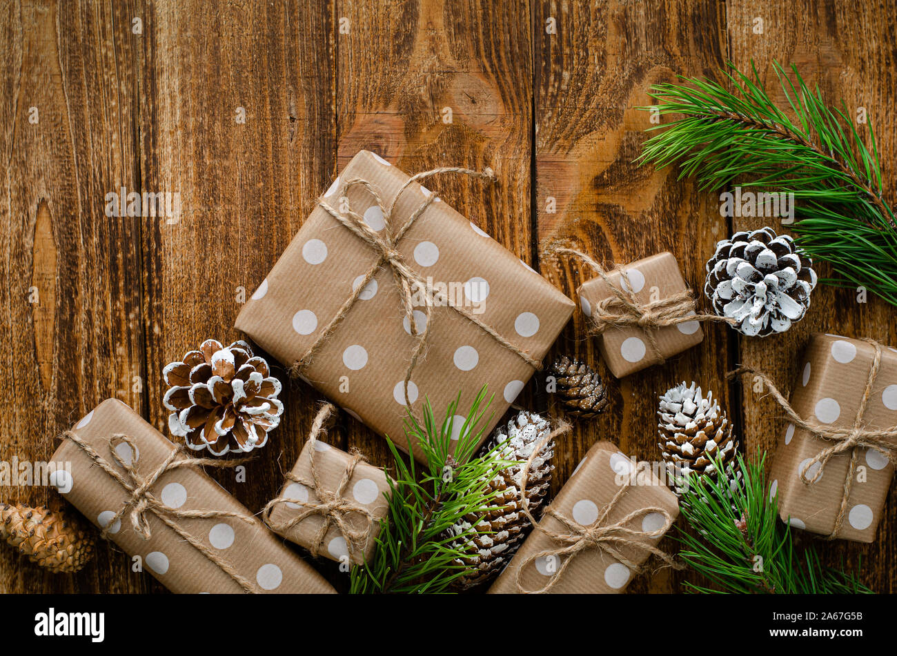 Christmas gift boxes wrapped in a craft paper, cones and fir branches ...