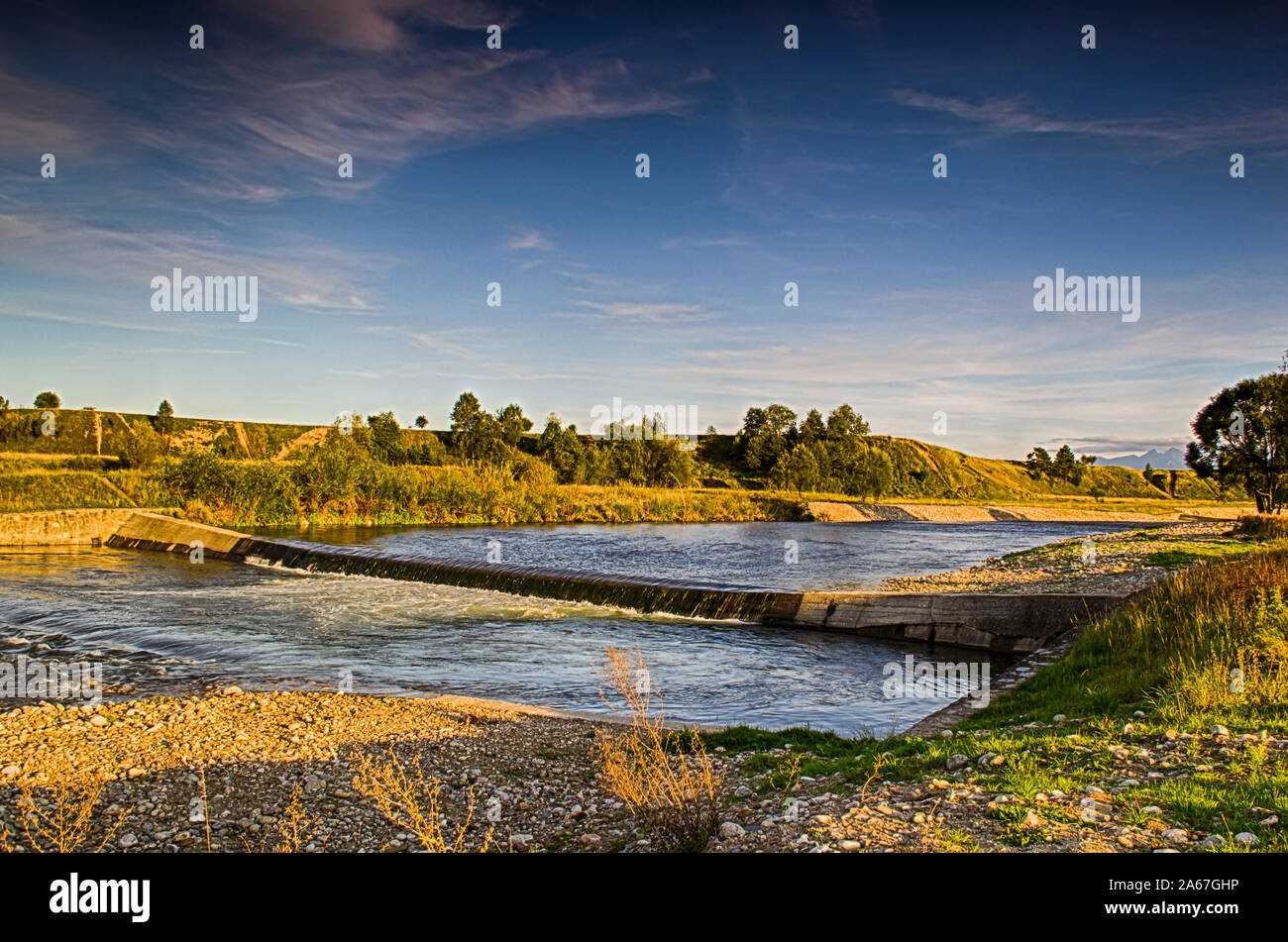 View of the Czarny Dunajec river and distant mountains. Stock Photo