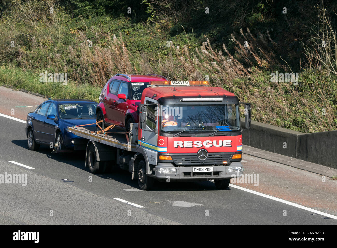 A breakdown rescue & recovery Mercedes truck transport semi truck traveling on the M6 motorway near Preston in Lancashire, UK Stock Photo
