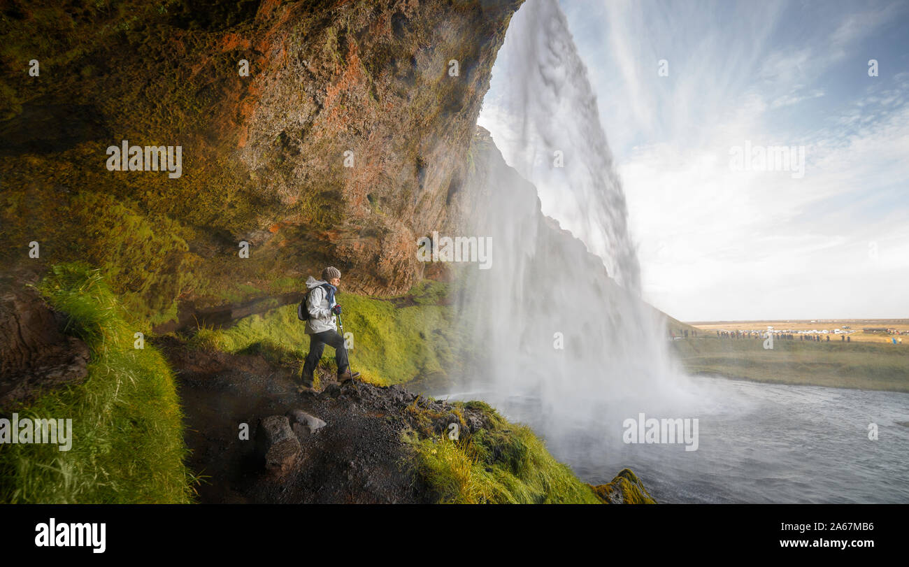 Hiker Woman Looking at the Seljalandsfoss Waterfall  in Iceland Stock Photo