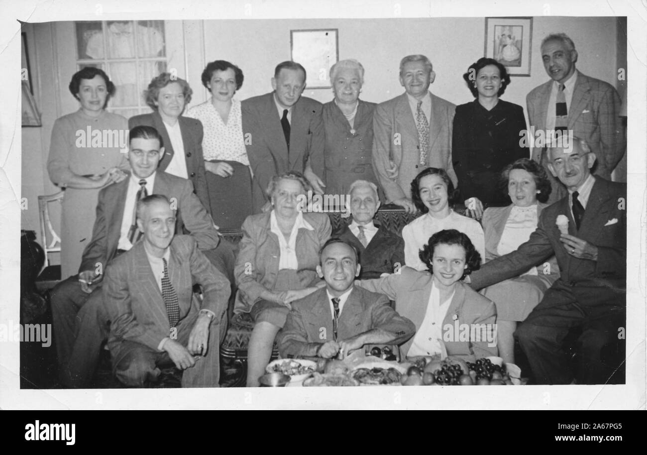 A large, multi-generational Jewish-American family poses for a group photograph with plates of food in the foreground, New York City, New York, 1949. () Stock Photo