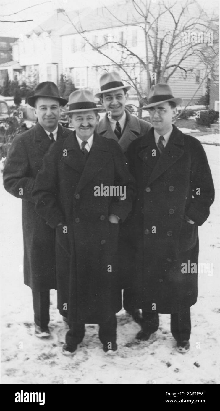 Four Jewish-American men, members of a family, stand outdoors in snow wearing heavy winter clothing and pose for a group photograph, New York City, New York, 1940. () Stock Photo