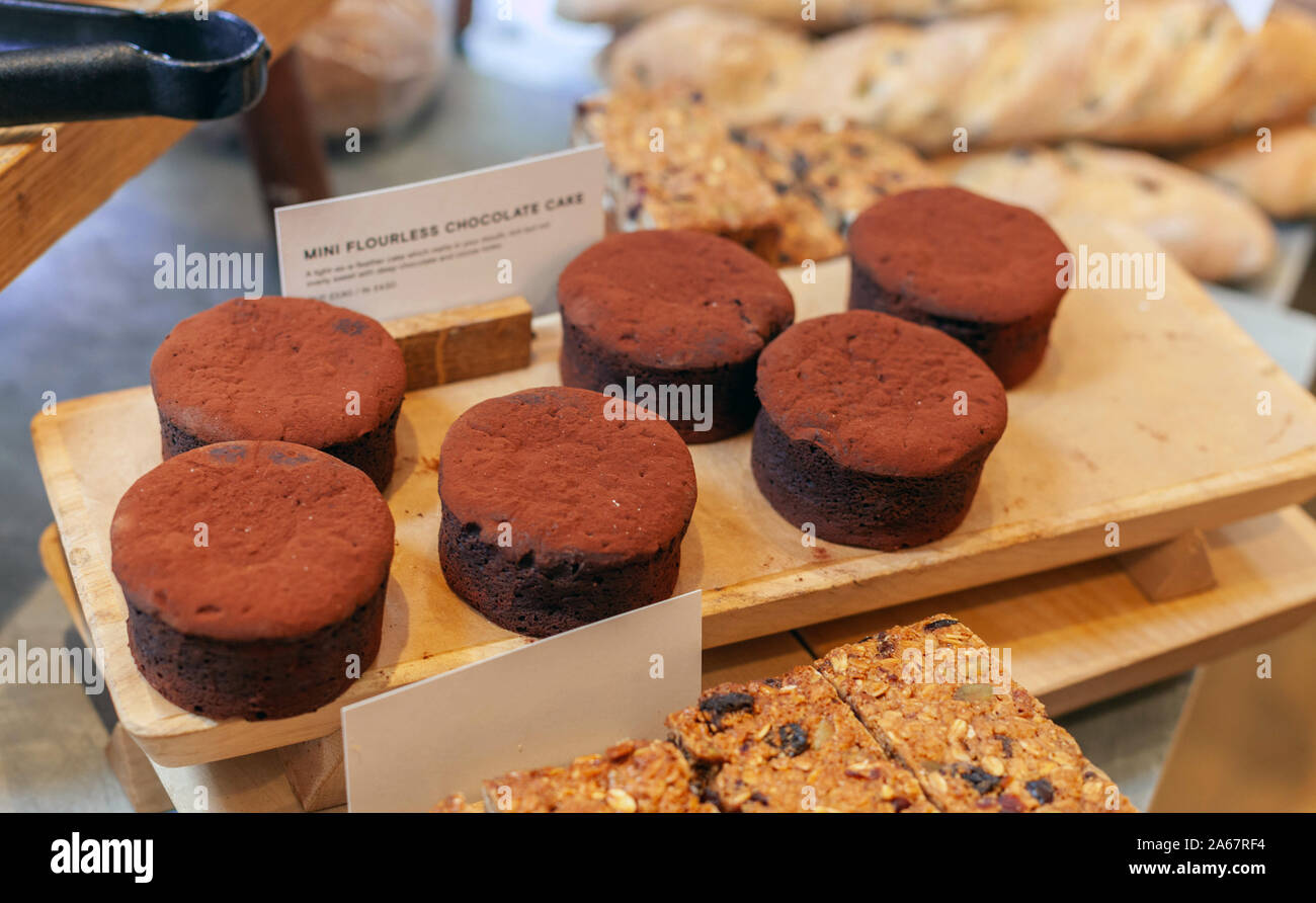 A tray of mini flourless chocolate cakes on display inside a bakery. Stock Photo