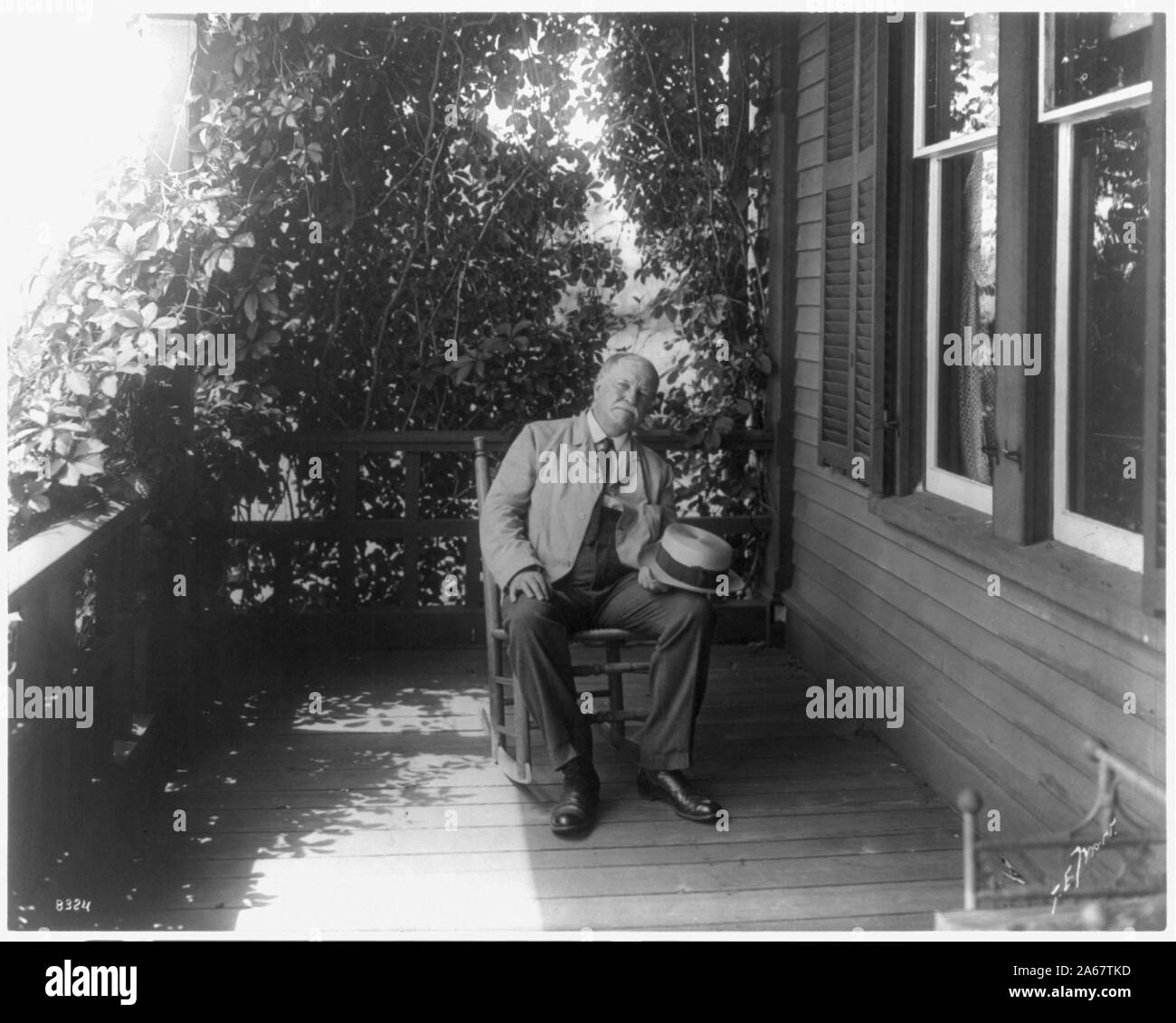 William Dean Howells, 1837-1920, full-length portrait, seated, facing right, on porch Stock Photo