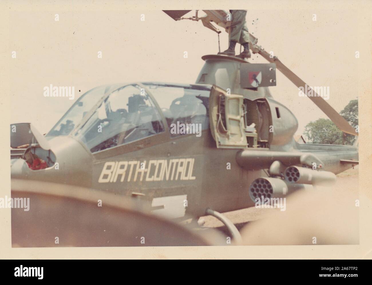 Bell Ah-1 Cobra Attack Helicopter With Rocket Launchers Visible In Vietnam  During The Vietnam War, With Spray Painted Message Reading Birth Control,  Referring Both To The Helicopter's Ability To Kill Members Of